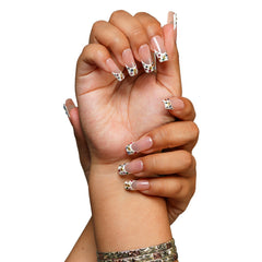 Las Vegas medium square press-on nails by 3H Nails, featuring a nude base with white French tips, multicolor rhinestones, and gold star accents, shown on hands.