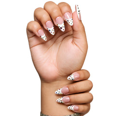 Dallas medium almond press-on nails by 3H Nails, featuring a nude base with white French tips, multicolor rhinestones, and gold star accents, shown in a lifestyle image.