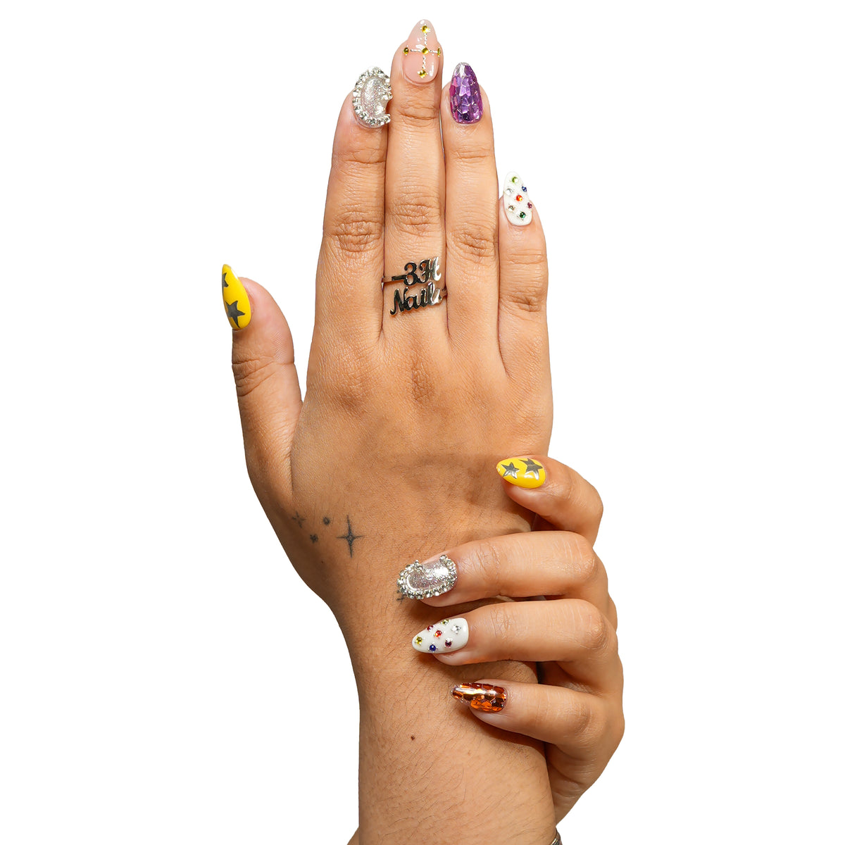 New Orleans medium almond press-on nails by 3H Nails, featuring jewel-tone gems, metallic stars, crystal accents, and reflective multicolor details, shown on hands.
