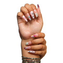 San Francisco medium almond press-on nails by 3H Nails, featuring pastel ombre color with hearts, stars, gems, metallic accents, and colorful French tips, shown on hands.