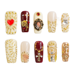 Gilded Relic long square press-on nails in burgundy, ivory and metallic gold with ornate vintage-inspired heart, cross, cameo and gem details.