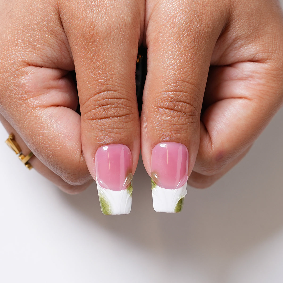 Close-up of Orchid Dreams long square press-on nails featuring raised green flowers, botanical accents and gold details.